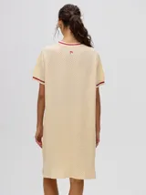 Vestido corto color crema con textura de red y detalles en color borgoña en cuello y mangas.