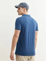 Chomba azul marino con pequeños lunares blancos, cuello clásico con botones y mangas cortas.