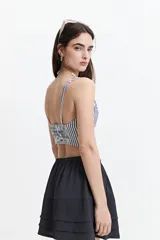 Top cropped a rayas verticales azules y blancas, con escote en V y elástico en la espalda.