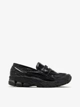 Mocasín New Balance 1906L negro con textura de piel de cocodrilo, suela acolchada 860v2 y almohadillas ABZORB SBS segmentadas en el talón.