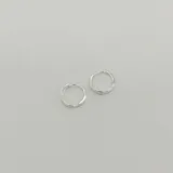 Aros tipo argolla de plata 925 con diseño cruzado y acabado satinado.