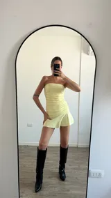 Vestido corto de lycra color amarillo pastel, sin mangas y con escote strapless.