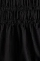 Vestido corto negro de algodón con cuerpo fruncido, escote cuadrado y breteles spaghetti dobles.