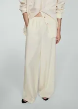 Pantalón de lino color crudo, de corte ancho y cintura elástica.