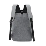 Mochila gris con doble bolsillo frontal con cierre, compartimento acolchado para laptop, puerto USB externo, asa de mano y faja trasera para acoplar a la manija de la valija.