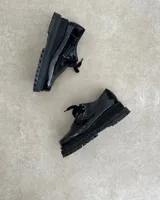 Zapato mocasín acordonado de cuero color marrón, con suela track negra y detalle de ribete color crema.