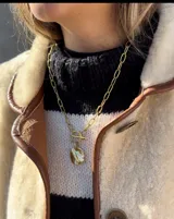 Collar plateado con cadena de eslabones y dije circular texturizado.