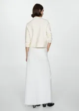 Suéter de punto fino color crudo, con cuello alto y mangas largas.