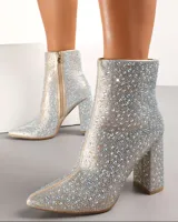 Bota corta plateada cubierta de strass, con punta fina, cierre lateral y tacón cuadrado. 
