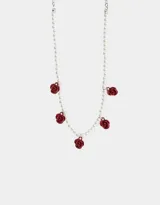 Collar corto de perlas blancas con dijes de rosas rojas.