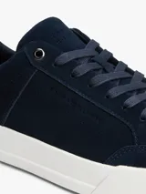 Zapatillas de tenis Tommy Hilfiger confeccionadas en ante color azul marino, con suela gruesa de goma blanca y detalle de panel a contraste en el talón en color tostado. Presenta cordones al tono y logo de la marca en bajo relieve en el lateral y el talón.