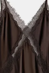 Vestido midi marrón de satén con tirantes finos ajustables y escote en V. Detalle de encaje a tono en el escote y la espalda. Cierre trasero con cremallera oculta.