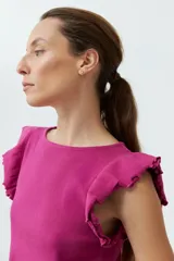 Top de punto canalé color fucsia, con escote redondo y mangas cortas con volados.