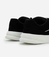 Championes negros de estilo skater con cordones gruesos blancos, suela blanca y detalles de líneas curvas blancas en los laterales.