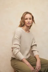 Sweater calado color beige de manga larga, cuello redondo y escote en la espalda con detalle de lazo.