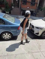 Bota corta de cuero color marrón, con taco de madera y punta cuadrada. Presenta una correa con hebilla alrededor del tobillo.