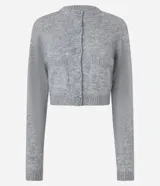 Cardigan cropped de punto color gris con cuello redondo, manga larga, cierre frontal con botones y bolsillos delanteros.