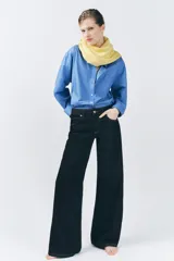 Jeans de tiro bajo con cintura con trabillas, cinco bolsillos, pespuntes marcados a contraste y pierna ancha.