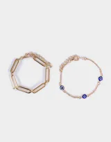 Set de dos pulseras doradas: una de eslabones grandes y otra de cadena fina con dijes de ojo turco.