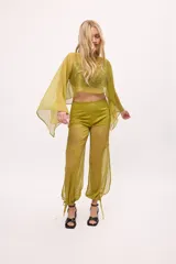 Pantalón negro traslúcido con corte ancho y ajuste en los tobillos.