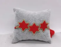 Pulsera tejida con cuentas doradas y azul oscuro, con tres dijes en forma de estrella.