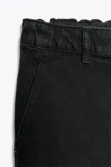Pantalón de jean negro con efecto lavado, tiro alto, corte carrot fit, cintura elástica en la parte trasera, bolsillos delanteros y traseros, cierre frontal con cremallera y botón metálico.