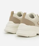 Championes urbanos color beige con detalles en cuero sintético y gamuza. Presentan cordones blancos, suela chunky y recortes contrastantes.