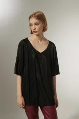 Blusa negra con cuello en V y mangas cortas, de tejido plisado.