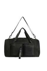 Bolso deportivo tipo duffel bag, color negro, con múltiples bolsillos frontales con cierre y asas de mano cortas. Incluye correa ajustable y desmontable para llevar al hombro. Posee un tirador textil con la palabra "TRENDY" en relieve.