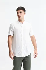 Camisa blanca de manga corta con cuello mao y doblez en las mangas.
