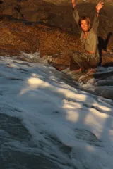 Saco de tejido ligero color beige, de manga larga y corte abierto, con cuello redondo.