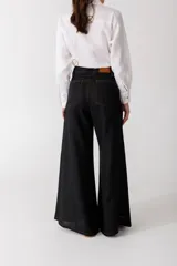 Pantalón de lino color crudo con finas rayas verticales negras, corte wide leg y tiro alto.