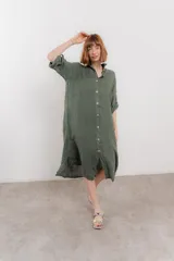 Vestido camisero midi color verde militar, de lino 100%, con silueta oversize, cuello camisero, mangas 3/4 con botón para ajustar y aberturas laterales.