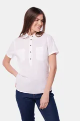 Camisa de lino color beige, de manga corta, con medio botón, dos bolsillos en el pecho y botones metálicos personalizados.