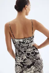 Vestido midi ajustado con breteles finos y escote drapeado. Presenta frunces laterales que generan un efecto drapeado.