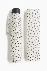 Paraguas plegable con funda, color blanco con lunares negros.