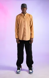 Camisa manga larga color mostaza de calce relaxed fit. Cuenta con detalles de canesú en frente y espalda, y aberturas en laterales. Su tela gamuzada le brinda a la prenda una textura de exclusiva suavidad.