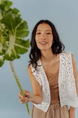 Chaleco blanco de encaje con corte sastrero y cuello redondo.