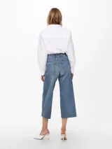 Pantalón de jean celeste, de tiro alto, corte wide leg y largo cropped.