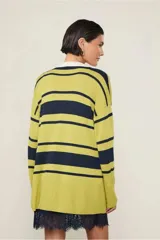 Sweater de punto verde con rayas horizontales azul marino y cuello polo blanco.