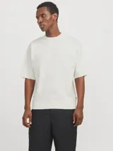 Remera color crema de tejido plano con fit relajado y hombros caídos, cuello redondo y mangas cortas.