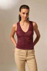 Top negro sin mangas de poliéster, con escote en V profundo y frunces en la parte delantera.