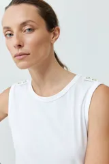 Musculosa roja de algodón con cuello redondo y botones decorativos en los hombros.