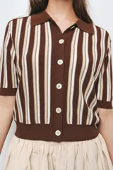 Chaqueta de punto marrón con rayas verticales en blanco y beige, cuello polo, manga corta y cierre frontal con botones.