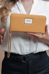 Billetera larga color gris de símil cuero, con cierre alrededor, múltiples compartimentos internos para tarjetas y documentos, bolsillo con cierre y correa de mano.