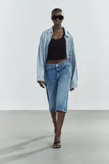 Bermuda jorts de denim celeste con efecto lavado, tiro bajo y cinco bolsillos. Cierre frontal con cremallera y botón metálico.