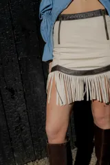 Minifalda marrón de cuero ovino con flecos y cierre frontal.