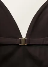 Top negro con tirantes finos, escote en pico y bajo con volantes. Cierre de gancho en la parte posterior y abertura en la espalda.