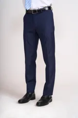 Traje de vestir azul marino, compuesto por saco de dos botones con solapa de muesca, dos bolsillos laterales con solapa y un bolsillo de ojal en el pecho, y pantalón de vestir con corte recto. Incluye camisa blanca, corbata celeste y pañuelo de bolsillo blanco con borde celeste.