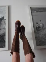 Botas altas de gamuza color marrón combinadas con cuero color marrón oscuro, forradas en cuero y con cierre de bronce.